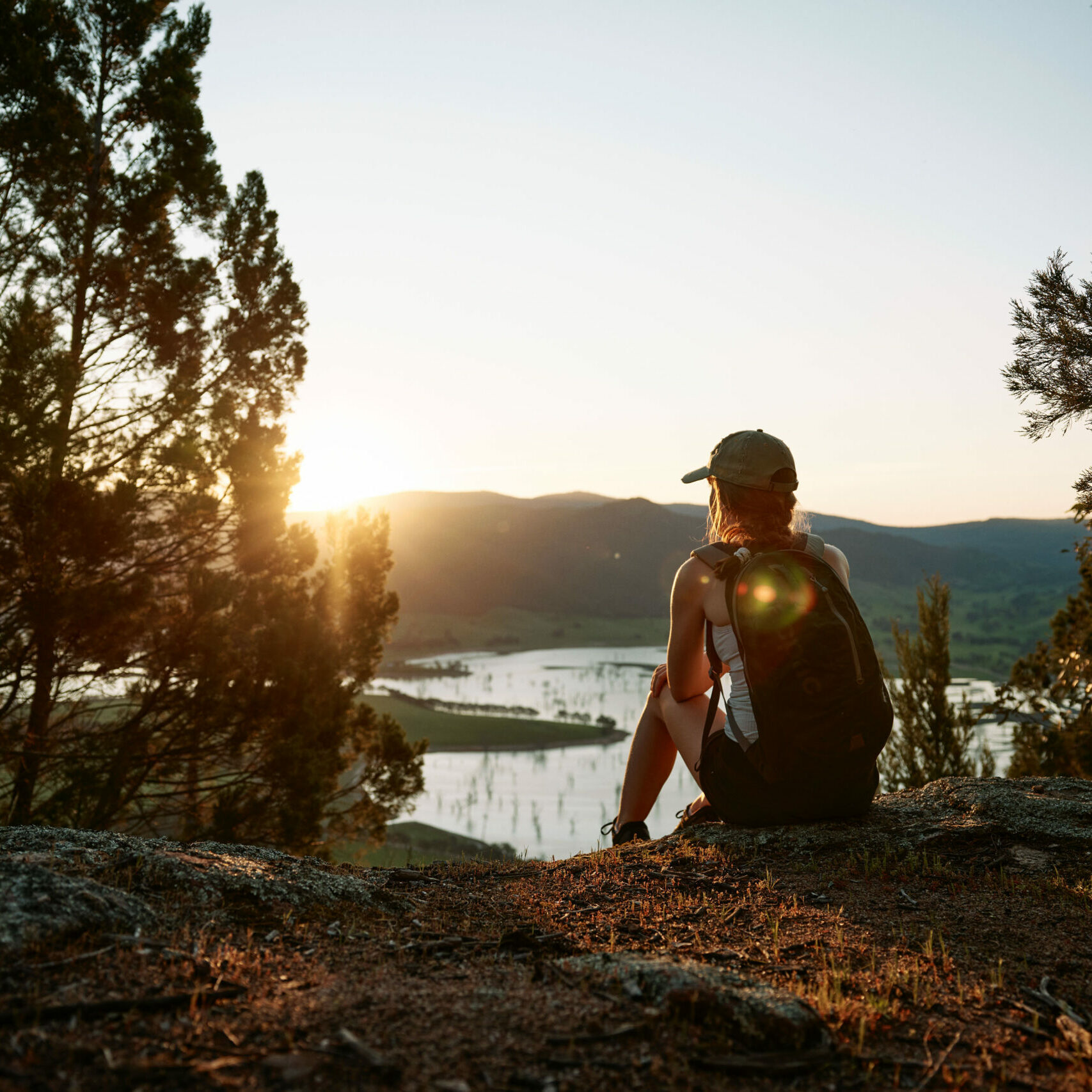 Person sitting at a scenic lookout, taking in expansive views along the Great River Road and savoring a moment of calm in nature.