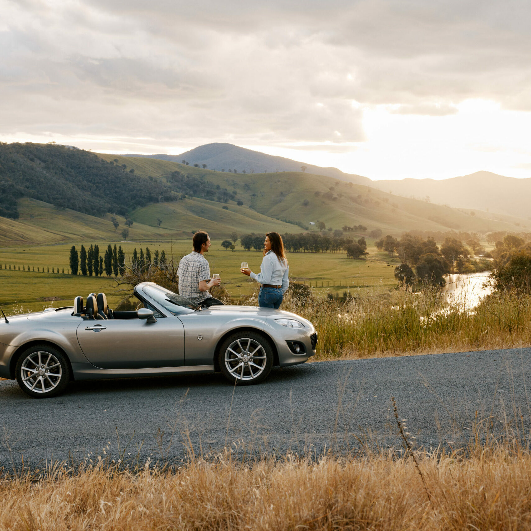 Scenic lookout along the Great River Road with sweeping Murray Valley views; a couple is seen near a car in the background, embodying the spirit of adventure and leisurely exploration.