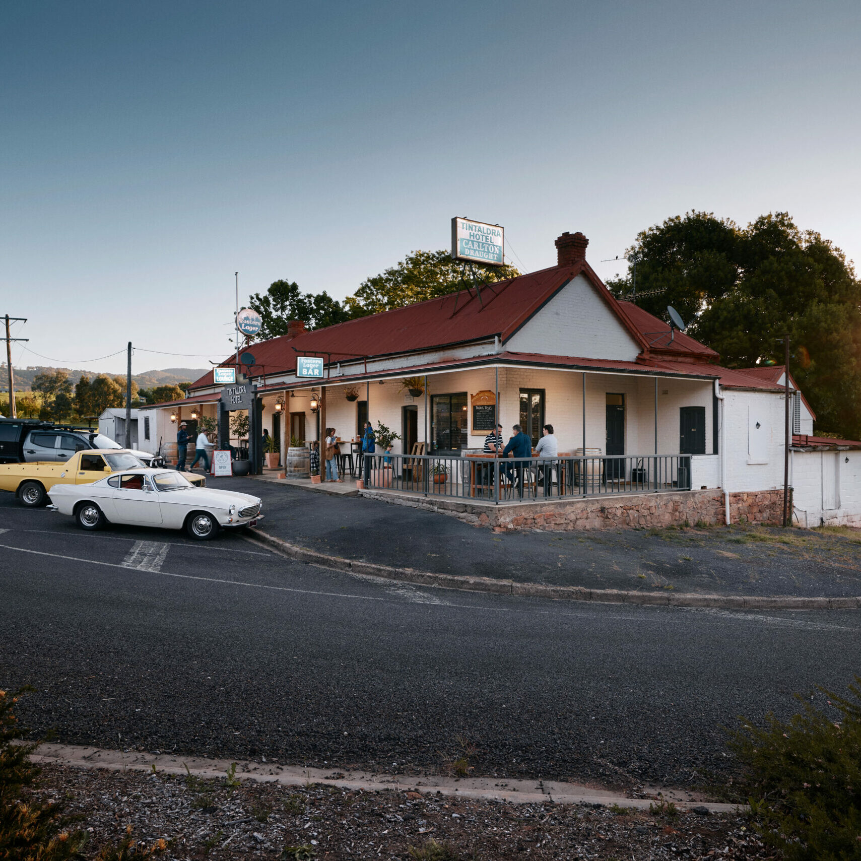 A pub with outdoor seating and a few parked cars, reflecting the scenic and inviting atmosphere of The Great River Road destination.