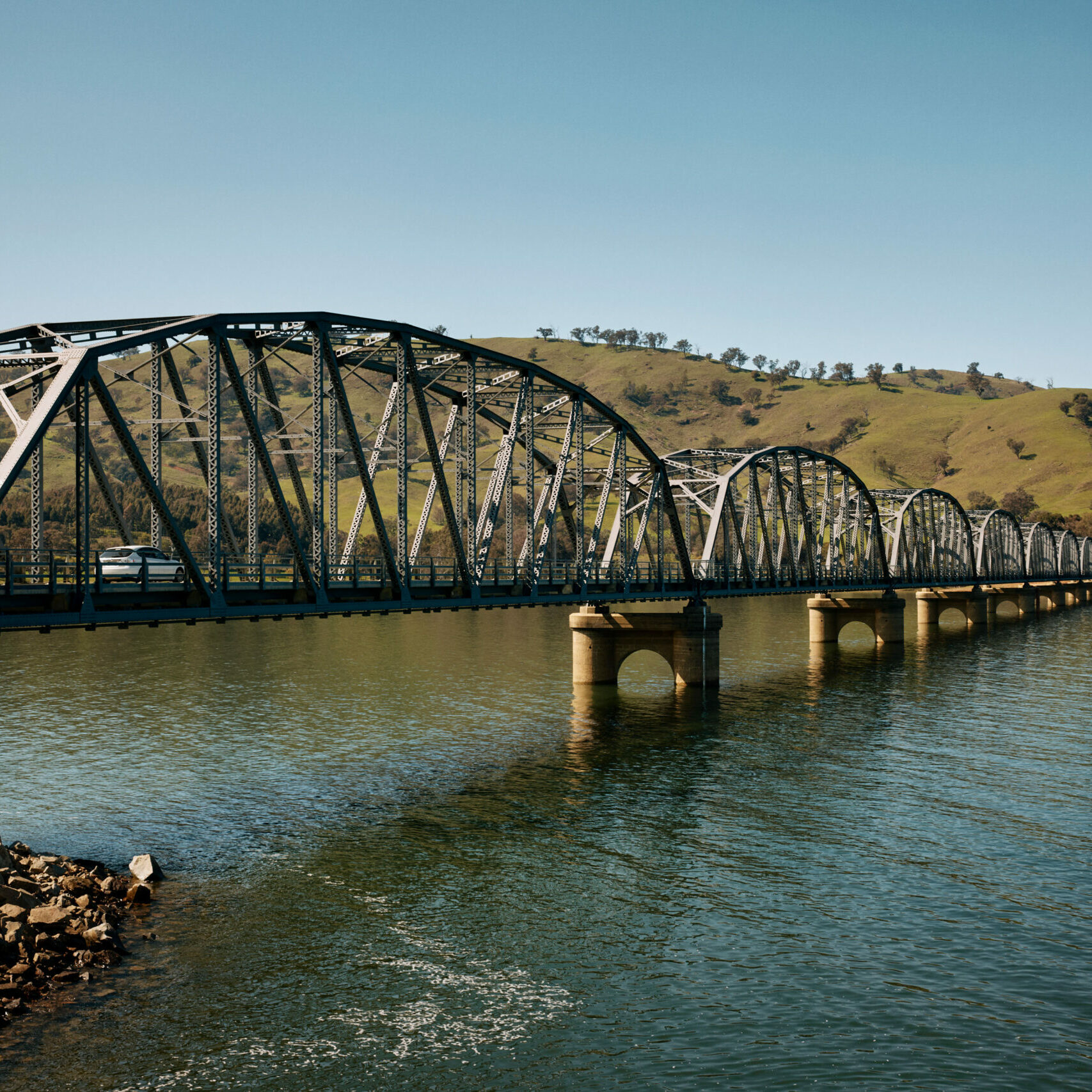 A scenic bridge marking the start of the 155 km Great River Road from Lake Hume to the Murray River’s source, set against dramatic landscapes and historic towns.