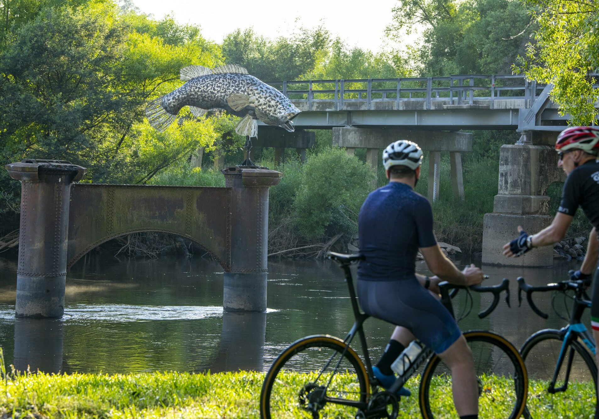 Two cyclists relaxing next to the Murray River at Tintaldra Bridge on the Border Loop